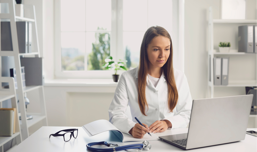 Provider taking notes at a laptop
